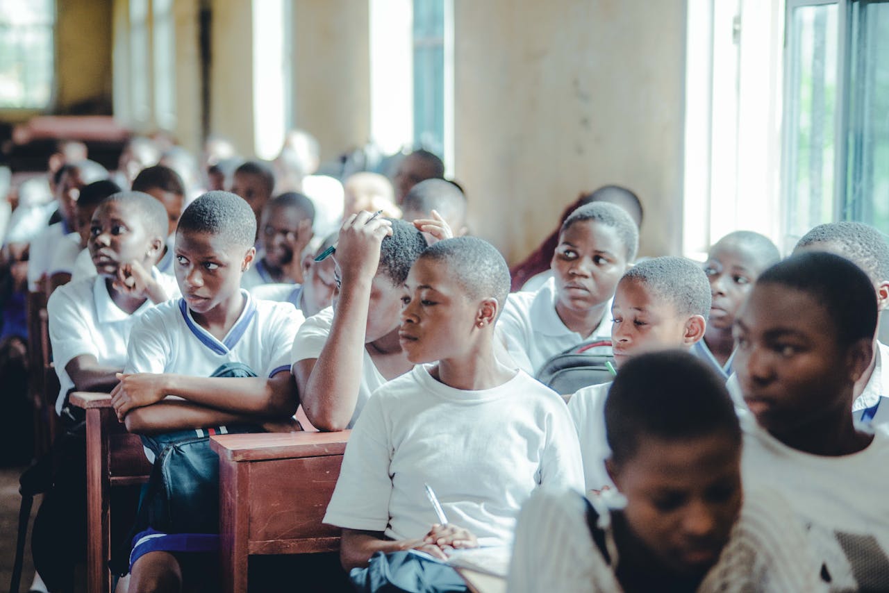 gallery-2 Engaged students in uniforms attentively participating in a classroom setting.